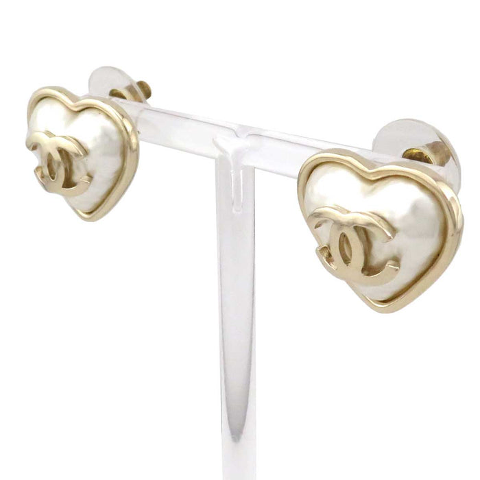 CHANEL 
B22C logo metallo color oro chiaro 
orecchini a bottone con perla di cotone a forma di cuore con logo Coco