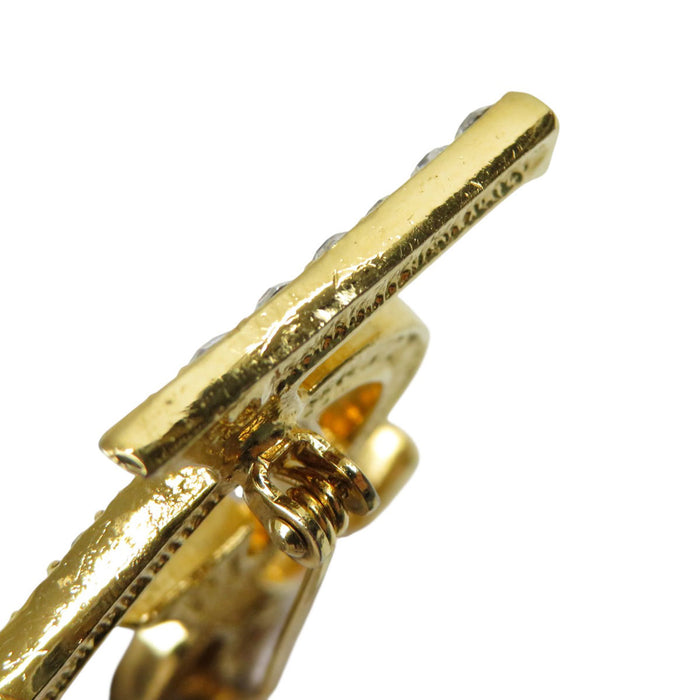 YVES SAINT LAURENT 
Metallo color oro 
Spilla con logo YSL e strass