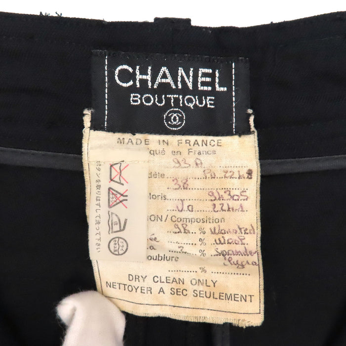 CHANEL  
COCO CC Bouton Coco Pantalon fuselé en laine  
Pantalon à plis centraux avec logo Coco