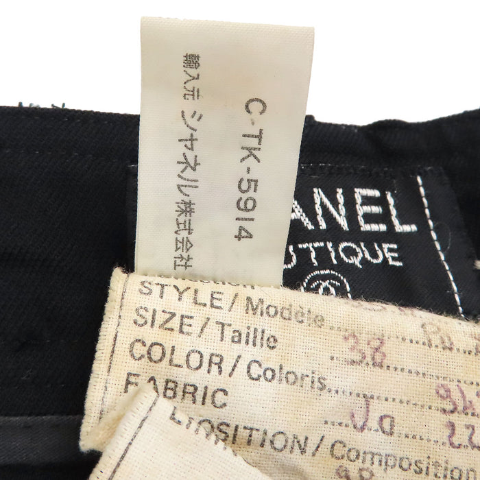 CHANEL  
COCO CC Bouton Coco Pantalon fuselé en laine  
Pantalon à plis centraux avec logo Coco