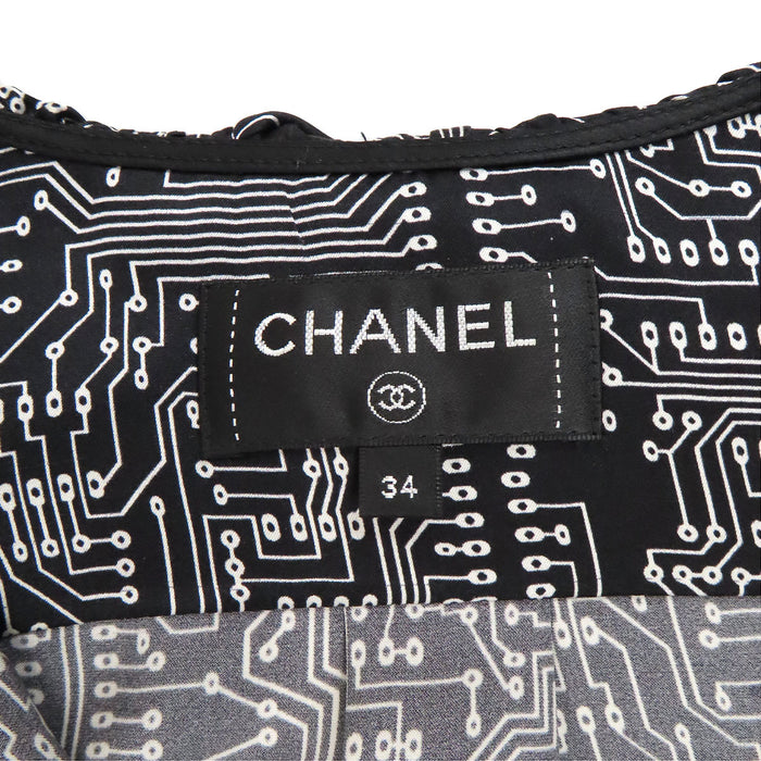 CHANEL  
COCO CC logo motif intégral bouton perle costume volant 17S  
Chemise manches longues en soie avec logo Coco
