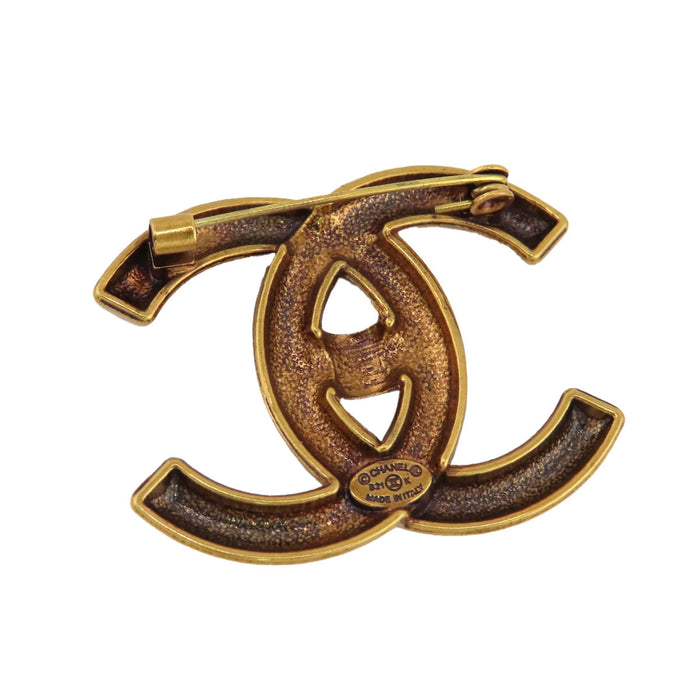 CHANEL  
COCO CC B21K métal couleur or  
Broche logo tourniquet Coco Mark