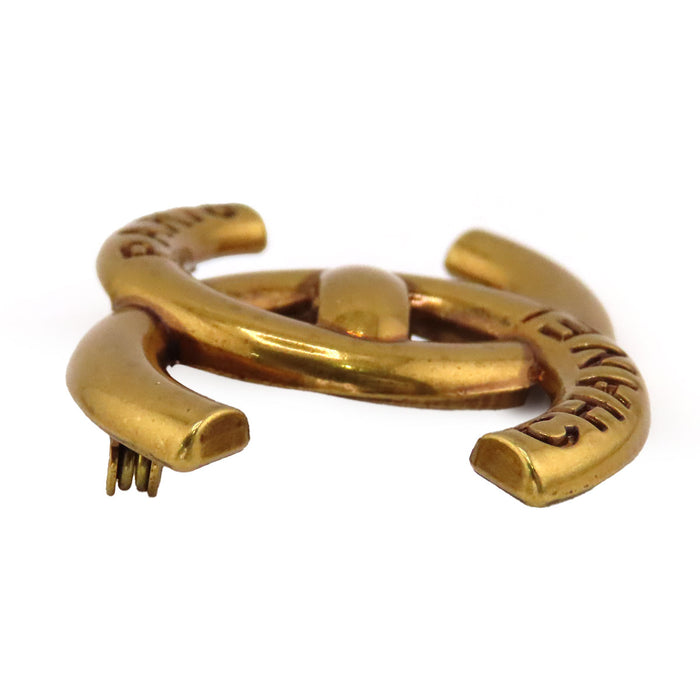 CHANEL  
COCO CC B21K métal couleur or  
Broche logo tourniquet Coco Mark