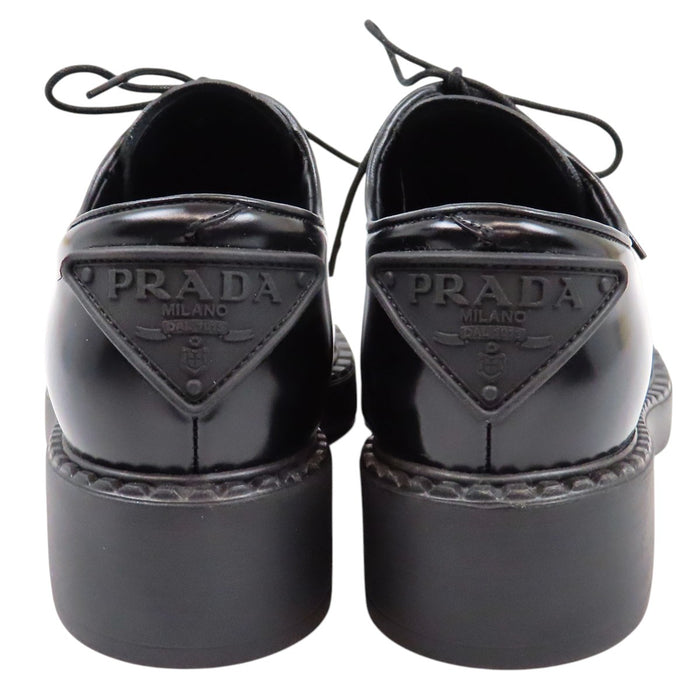 PRADA  
Derbies en cuir brossé à lacets avec plaque triangulaire  
Logo triangulaire