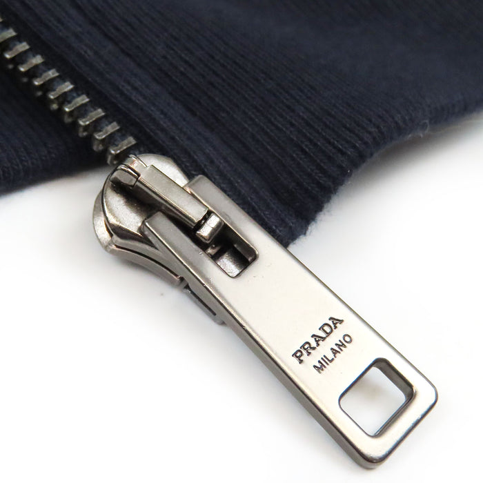 PRADA  
Sweat à capuche en coton avec logo en caoutchouc et empiècements en nylon  
Veste zippée avec logo latéral