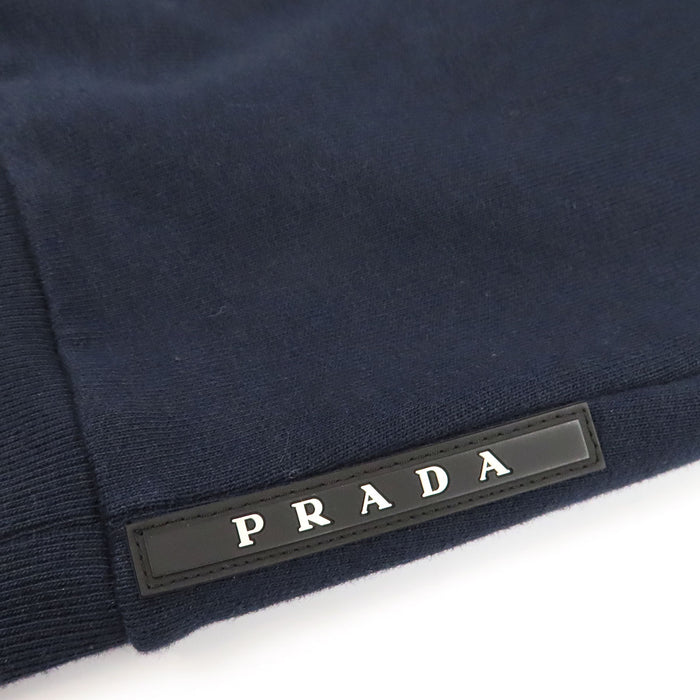 PRADA  
Sweat à capuche en coton avec logo en caoutchouc et empiècements en nylon  
Veste zippée avec logo latéral