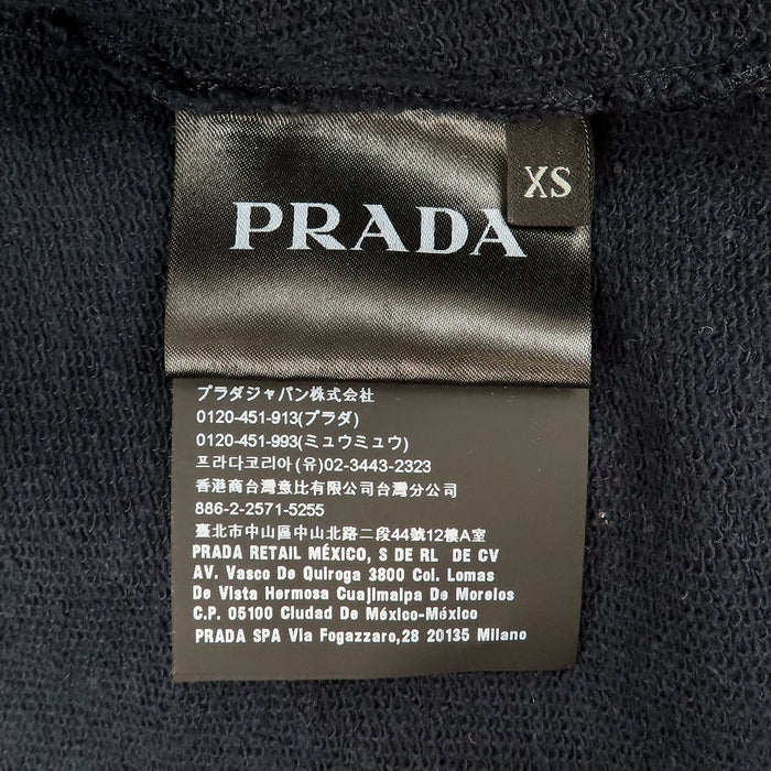 PRADA  
Sweat à capuche en coton avec logo en caoutchouc et empiècements en nylon  
Veste zippée avec logo latéral